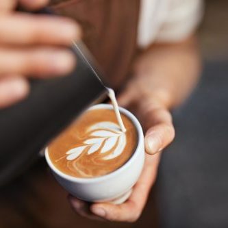 Coffee Art In Cup. Closeup Of Barista Hands Making Latte Art  Picture With Milk On Coffee. High Resolution