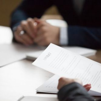 Businesspeople sitting office desk at meeting. Woman ceo holding pen and contract, ready to sign document, close up. Client, customer lease agreement buy sell real estate. Successful deal, hr concept
