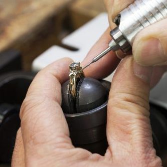 A Jeweller is Repairing a Diamond Ring.